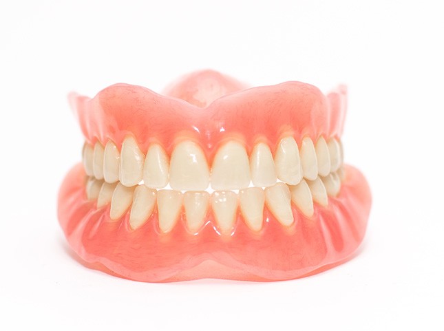 Complete set of shiny dentures with a white background