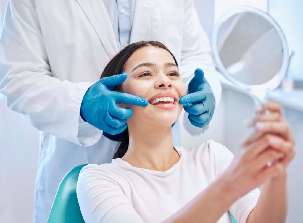 A woman looking in a mirror at her new smile